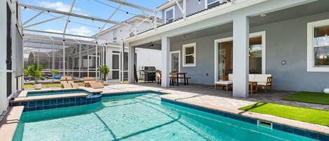A swimming pool with a glass ceiling, outdoor seating, and a patio area.