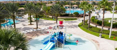 Un parc aquatique doté d’une structure de jeux centrale, de plusieurs piscines et entouré de palmiers.
