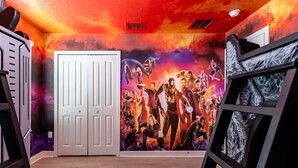 A room with a starry mural on the wall, a white door, and a bed with a metal frame. - Themed 9BR Villa Pool Game Room Champions Gate (Davenport)