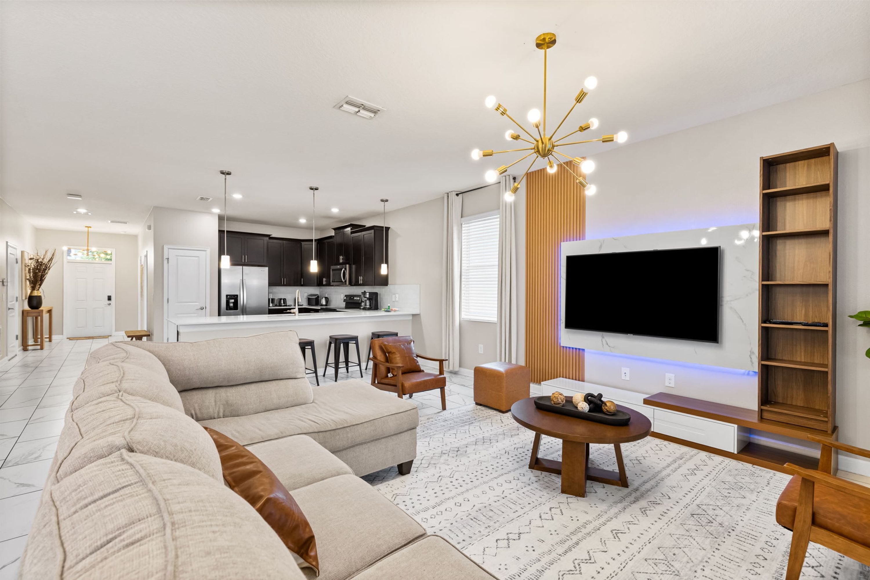 Ein modernes Wohnzimmer mit einer Eckcouch, einem Couchtisch und einem an der Wand montierten Fernseher.