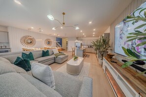 Ein modernes Wohnzimmer mit einem Ecksofa, einem Couchtisch und einem Fernseher.