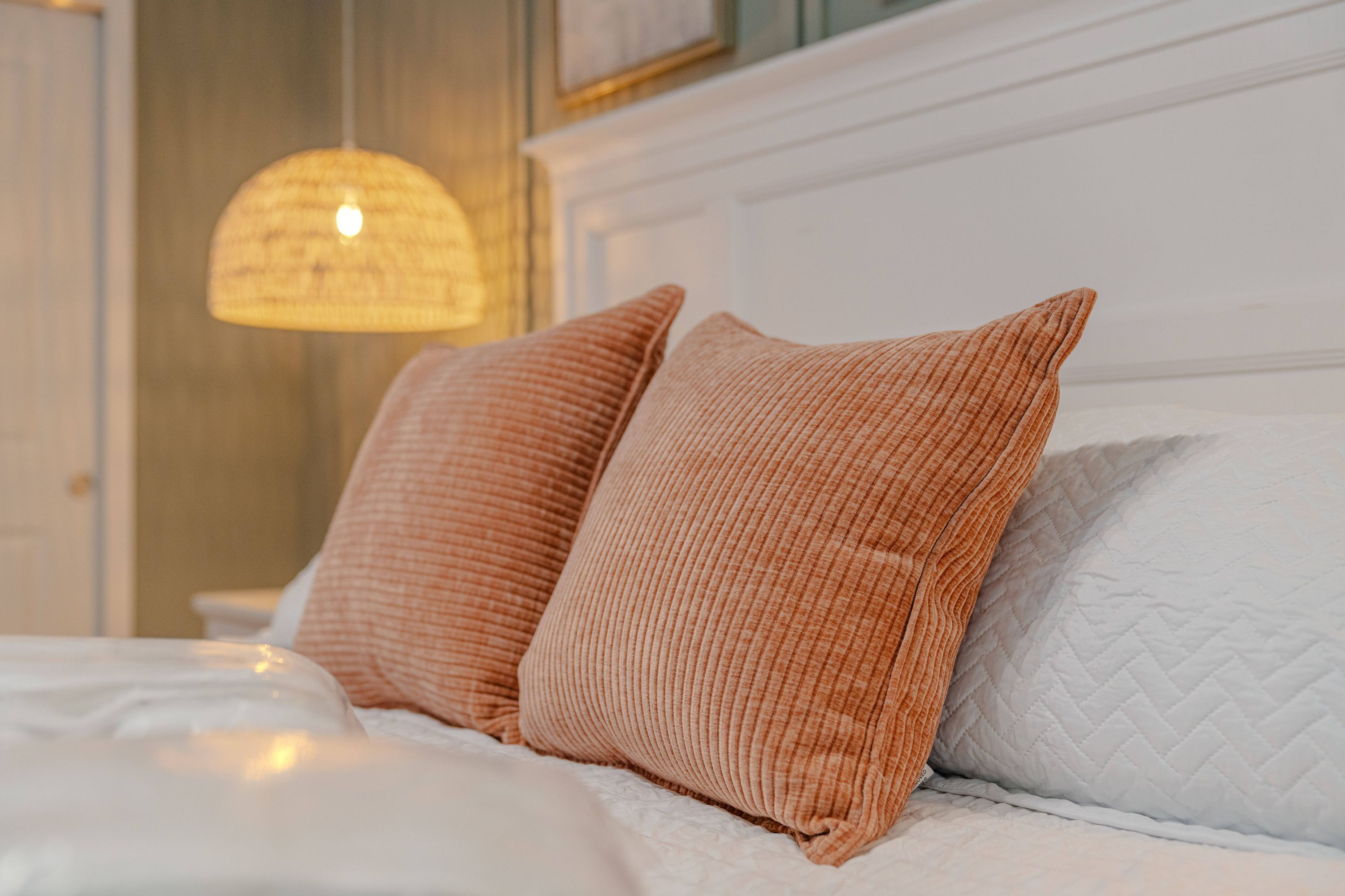 Ein Bett mit zwei Kissen und einer weißen gesteppten Decke.