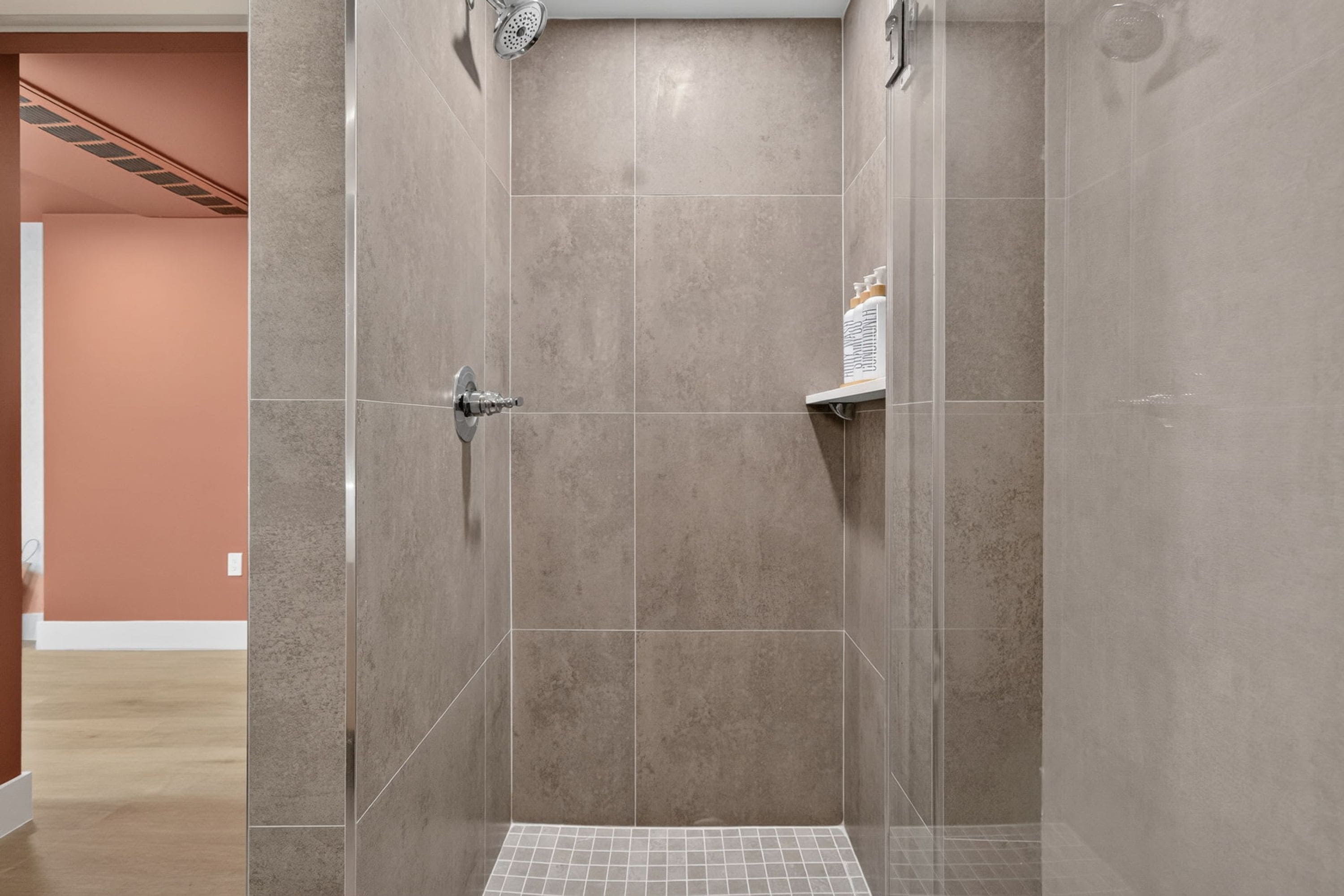 Une douche à l’italienne avec un sol carrelé et un pommeau de douche.