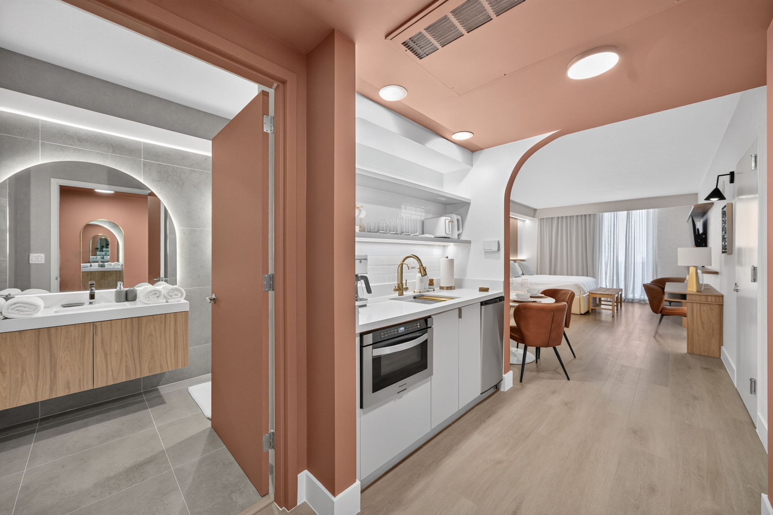 Une cuisine moderne dotée d’un îlot central, d’appareils électroménagers intégrés et d’un coin repas offrant une vue agréable.