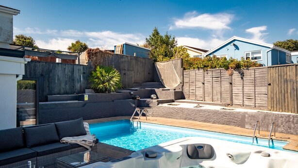 A backyard with a swimming pool, a hot tub, and outdoor seating. - Vitamin Sea - Swimming Pool Hot Tub Sea Views (Saundersfoot)