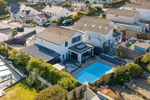 A residential area with modern houses, a swimming pool, and a well-maintained garden. - Vitamin Sea - Swimming Pool Hot Tub Sea Views (Saundersfoot)