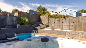 A backyard with a swimming pool, hot tub, and outdoor seating area. - Vitamin Sea - Swimming Pool Hot Tub Sea Views (Saundersfoot)