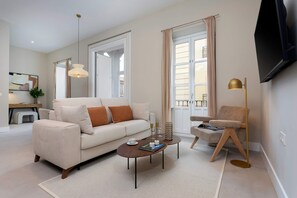 Ein modernes Wohnzimmer mit Sofa, Couchtisch und Stehlampe.