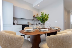 A modern dining area with a wooden table set for four, surrounded by woven chairs. - Genteel Home San Anton 102 (Granada)