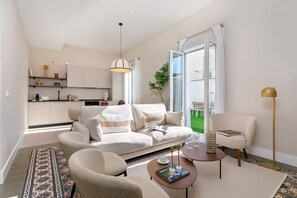 A modern living room with a sofa, armchairs, a coffee table, and a dining area. - Genteel Home San Anton 103 (Granada)