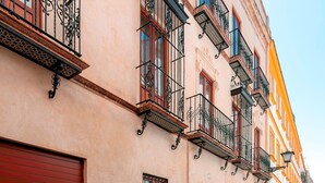 Una hilera de edificios con balcones, una puerta de garaje roja y un cielo despejado.