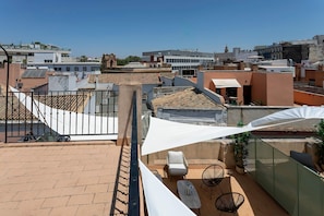 A rooftop terrace with a view of the cityscape, featuring a white umbrella, a chair, and a table. - Genteel Home Padre Marchena 13 202 (Seville)