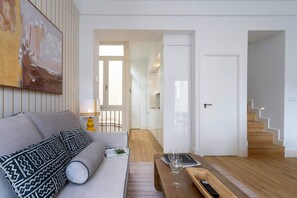 A modern living room with a sofa, coffee table, and a painting on the wall. - Genteel Home Padre Marchena 13 202 (Seville)