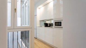 A modern kitchen with white cabinets, a microwave, and a coffee maker. - Genteel Home Padre Marchena 13 101 (Seville)