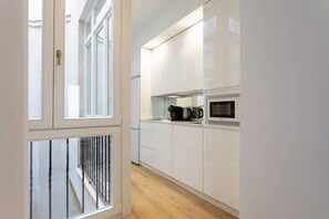 A modern kitchen with white cabinets, a microwave, and a coffee maker. - Genteel Home Padre Marchena 13 101 (Seville)