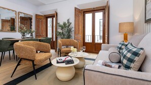 A modern living room with a sofa, chairs, a coffee table, and a dining area with a table and chairs. - Genteel Home Padre Marchena 13 101 (Seville)