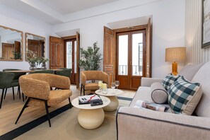 A modern living room with a sofa, chairs, a coffee table, and a dining area with a table and chairs. - Genteel Home Padre Marchena 13 101 (Seville)