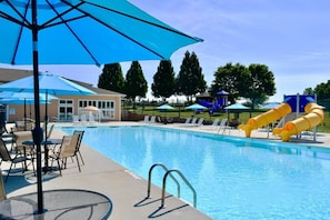 A swimming pool with lounge chairs, umbrellas, and a water slide. - #217 Pointe - 2 Bedroom Lakefront Condo at Mariners SML (Bedford County)