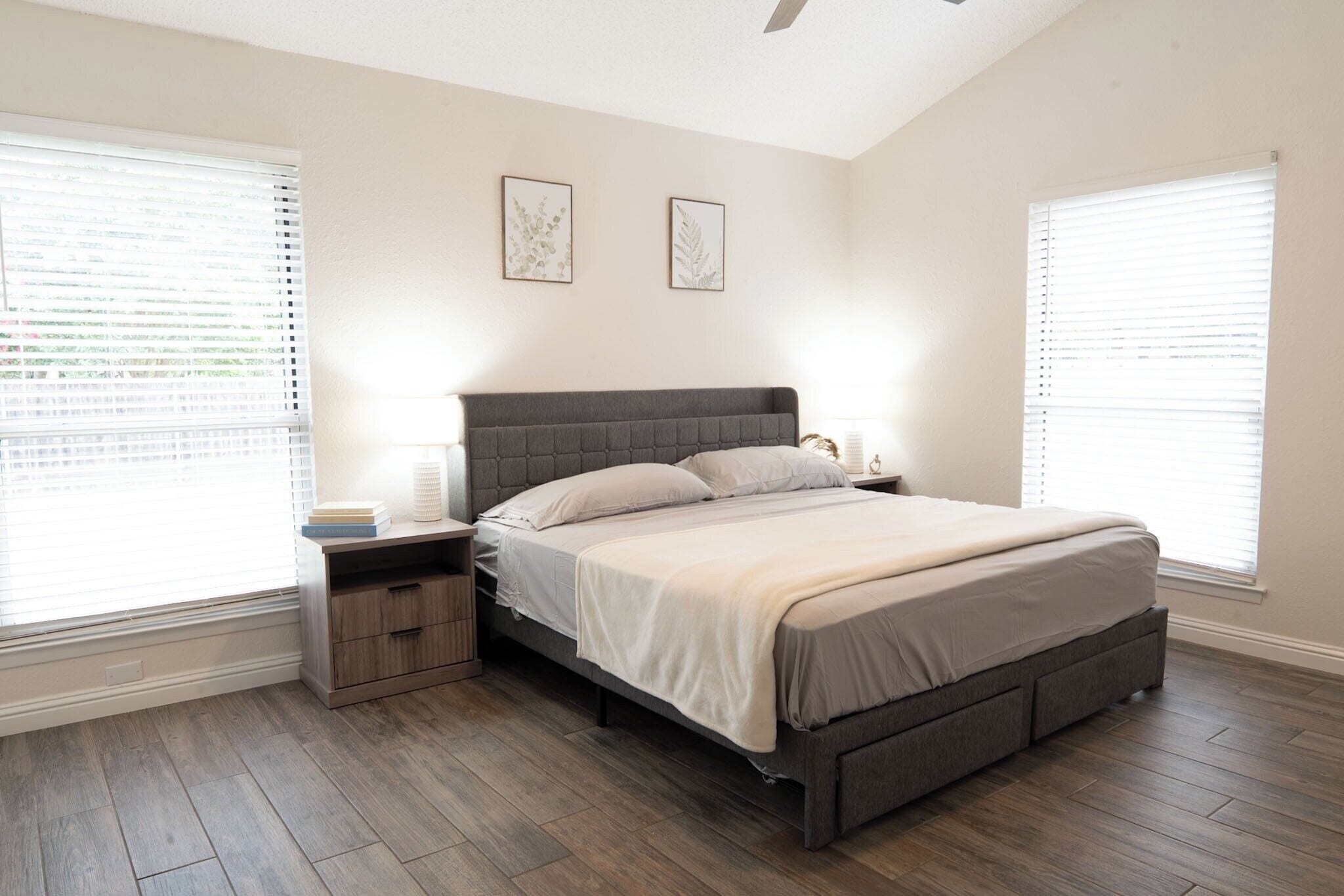 Une chambre à coucher avec un lit, des tables de chevet et une fenêtre.