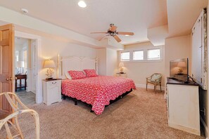 A bedroom with a bed, a ceiling fan, a TV, and a desk. - JL #472 On the Rocks - Oceanfront - Pool - Hot tub (Nags Head)