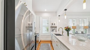 A modern kitchen with a stainless steel refrigerator, a marble countertop, and a built-in sink. - 2 Blocks to Beach | Screened-in Porch (Santa Rosa Beach)
