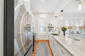 A modern kitchen with a stainless steel refrigerator, a marble countertop, and a built-in sink. - 2 Blocks to Beach | Screened-in Porch (Santa Rosa Beach)