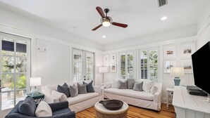 A spacious living room with a ceiling fan, white walls, and large windows. - 2 Blocks to Beach | Screened-in Porch (Santa Rosa Beach)
