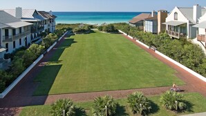 A golf course with a clear view of the ocean, surrounded by buildings with balconies. - Walk to Beach and Square | Private Pool (Inlet Beach)
