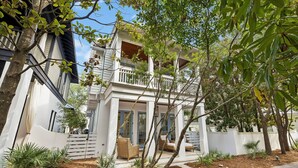 A modern two-story house with a balcony, surrounded by trees and plants. - Walk to Beach and Square | Private Pool (Inlet Beach)
