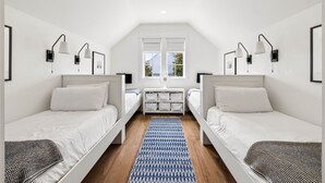 A room with two single beds, a small table with storage, a window, and a ceiling fan. - Walk to Beach and Square | Private Pool (Inlet Beach)