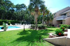 A pool area with lounge chairs and a building with a balcony. - Roomy 4BR Beach Home for 10 | Walk to Ocean (Myrtle Beach)