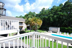 A pool area with a white fence, lounge chairs, and a lifeguard station. - Roomy 4BR Beach Home for 10 | Walk to Ocean (Myrtle Beach)