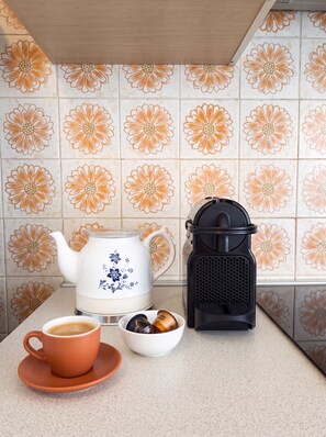 A kitchen counter with a coffee maker, a teapot, and a cup of coffee. - Quiet Milan Apartment for 3 – Balcony, Free Parking, 1 stop from Navigli (Milano)