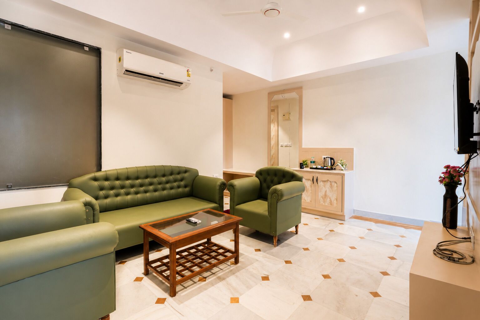 Una sala de estar con un sofá verde, una mesa de centro y un televisor.