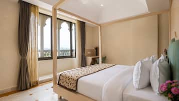 A modern bedroom with a four-poster bed, a desk, and a view of the outdoors.
