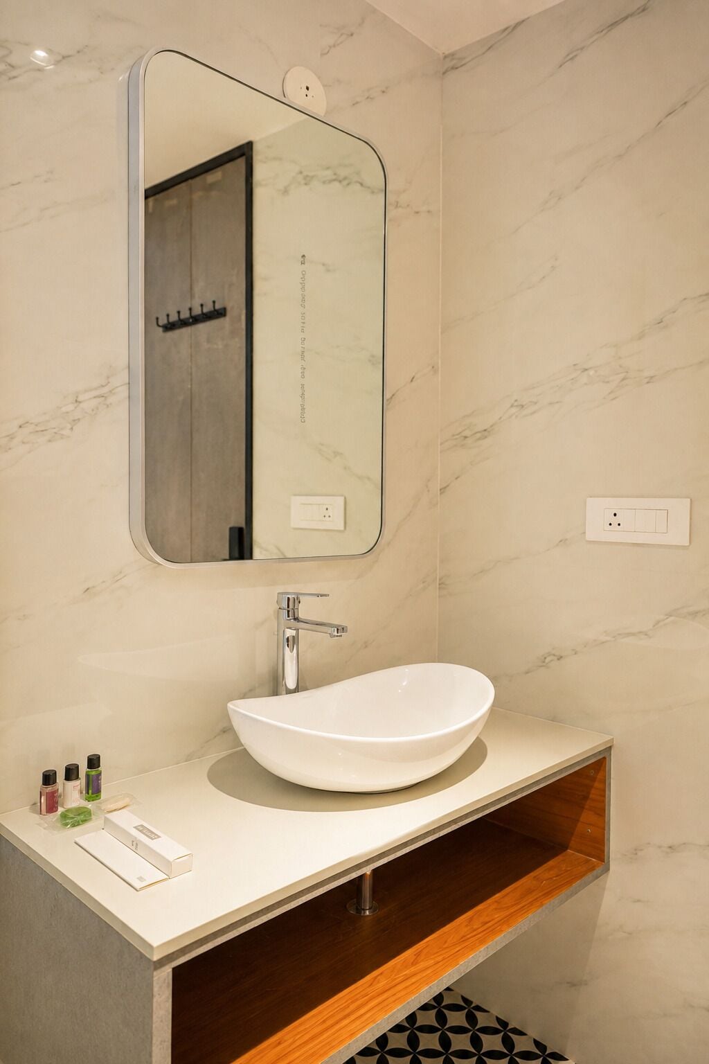 A bathroom with a white vessel sink, a mirror, and a wooden vanity.