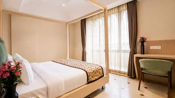 Una habitación de hotel con una cama, un escritorio y una silla.