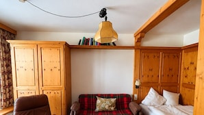 Una habitación acogedora con una cama de madera, un sofá, una silla y una mesa.