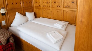 Ein Doppelbett mit weißer Bettwäsche, ein Holzkopfbrett und ein Nachttisch mit Lampe.