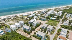 An aerial view of a coastal residential area with beachfront properties, a clear sky, and a calm sea. - Marimac's Maison|Private Pool|Elevator|Golf Cart (Inlet Beach)