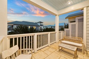 A covered outdoor patio with a view of houses and a sunset. - Marimac's Maison|Private Pool|Elevator|Golf Cart (Inlet Beach)