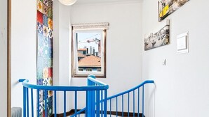 Uma escada em espiral com corrimãos azuis que leva a um andar superior.