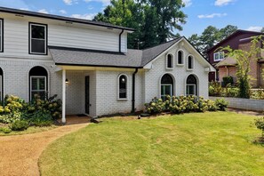 A two-story house with a covered porch and a well-maintained lawn. - Hoover Furnished Stay | Families & Pros (Birmingham)