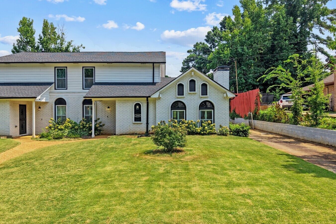A two-story house with a front yard and a driveway.