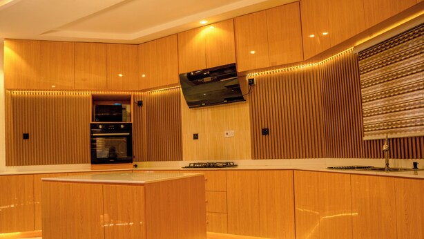 Een moderne keuken met houten kastjes, een centraal eiland en ingebouwde apparatuur.