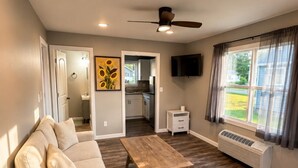 Un salon moderne avec un canapé, une table basse et un ventilateur de plafond.
