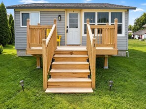 A two-story house with a wooden deck and a front door.