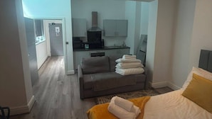 Ein Hotelzimmer mit einem Bett, einer Couch, einer kleinen Küchenzeile und einem separaten Essbereich.