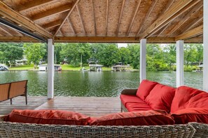 Ein überdachter Außenbereich mit Blick auf einen See und angestellte Boote.