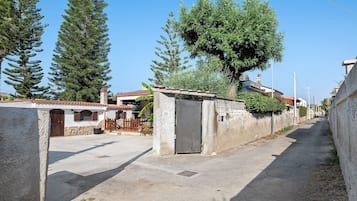 A residential street with houses, a paved road, and a clear sky.